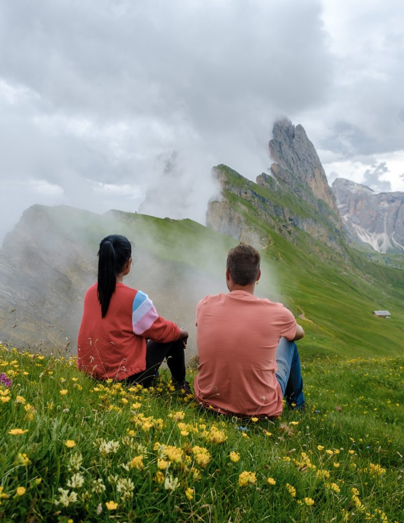 couple on vacation hiking in the Italian Dolomites, Amazing view on Seceda peak. Trentino Alto Adige